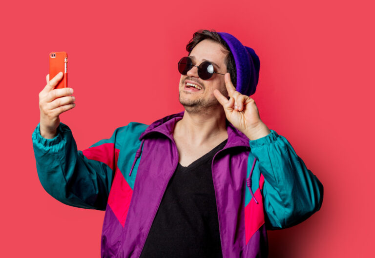 guy in a hat takes a selfie on a red background